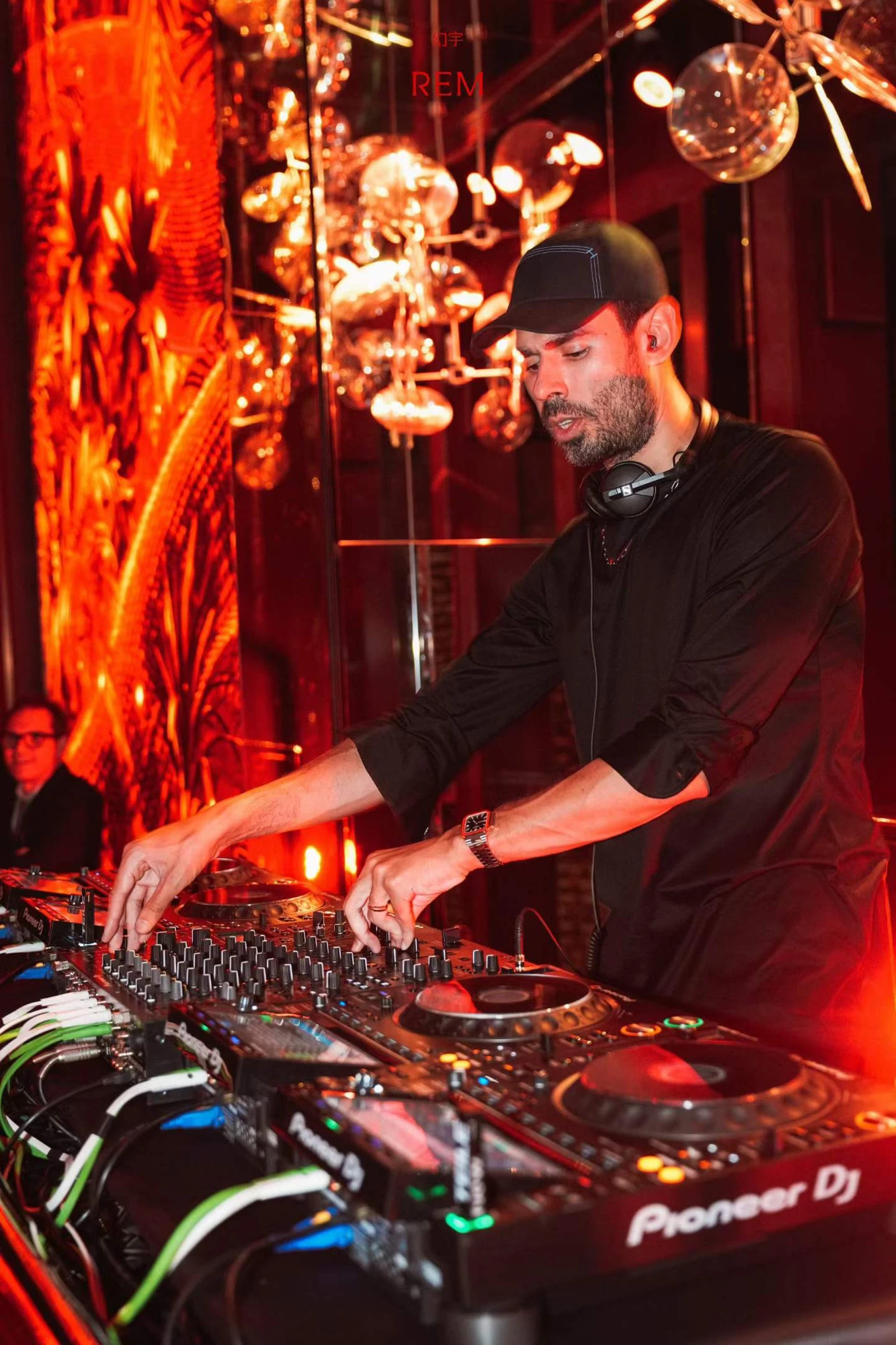 A DJ plays in the gold mirrored event setting