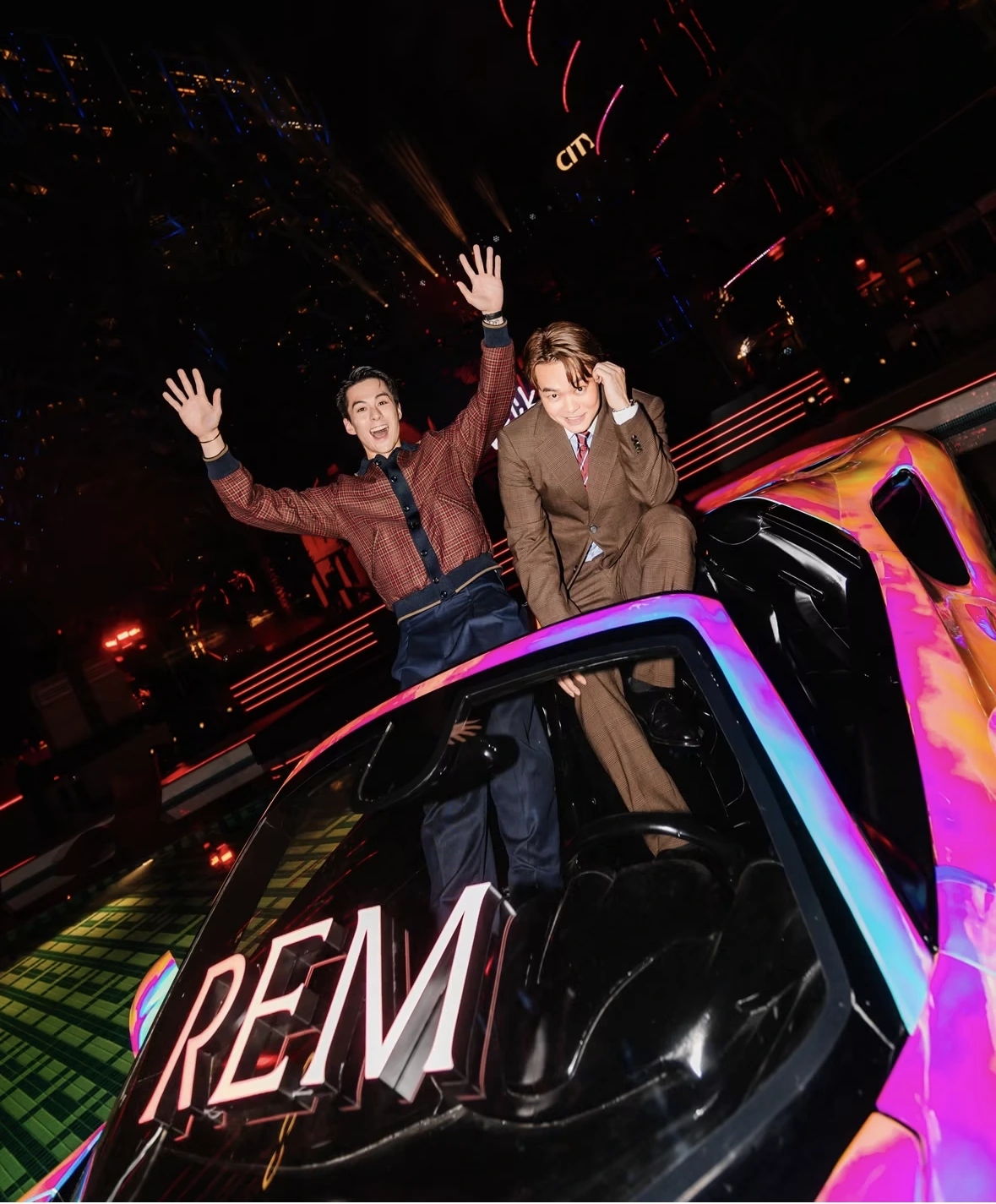 Two guests celebrating inside the iridescent REM car