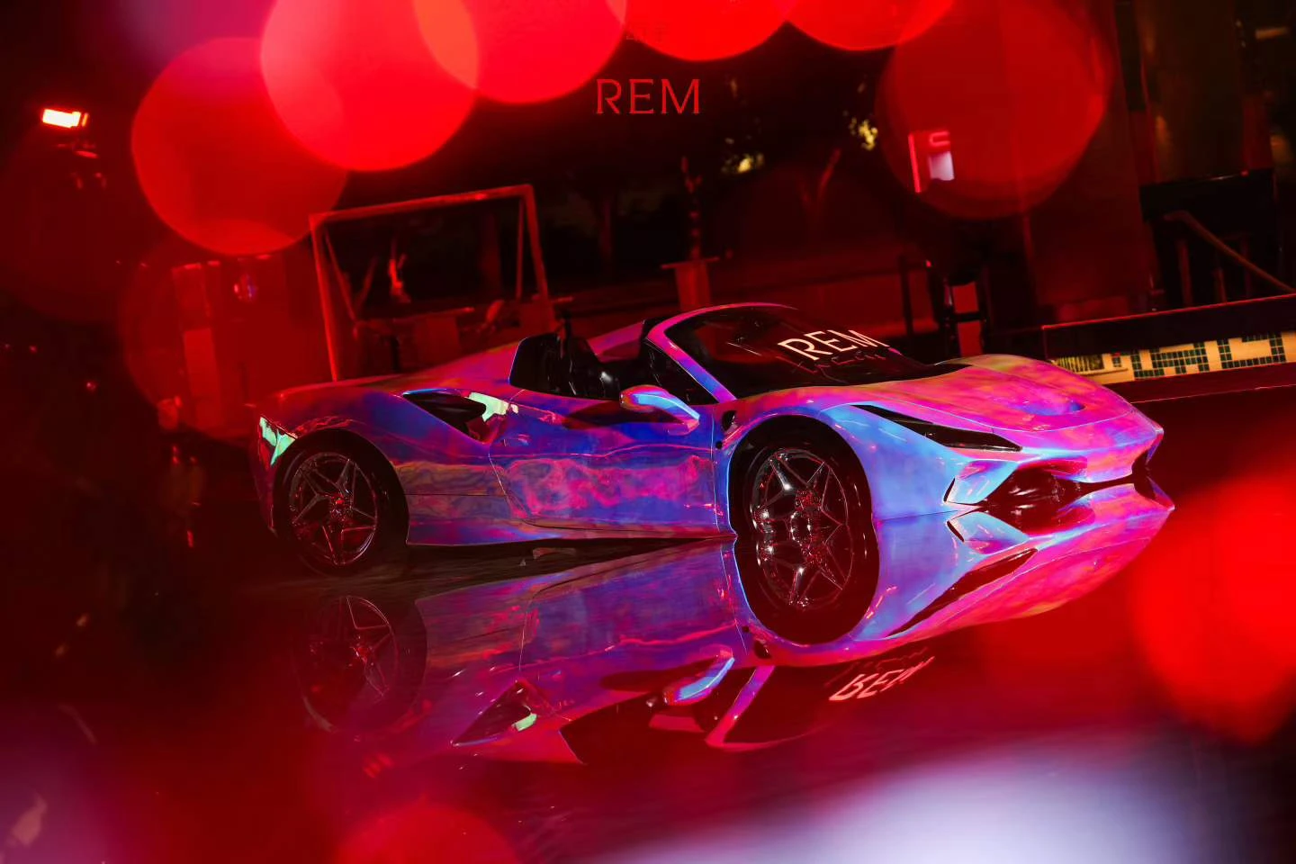 The iridescent REM dream car floating in the pool and reflected on the water