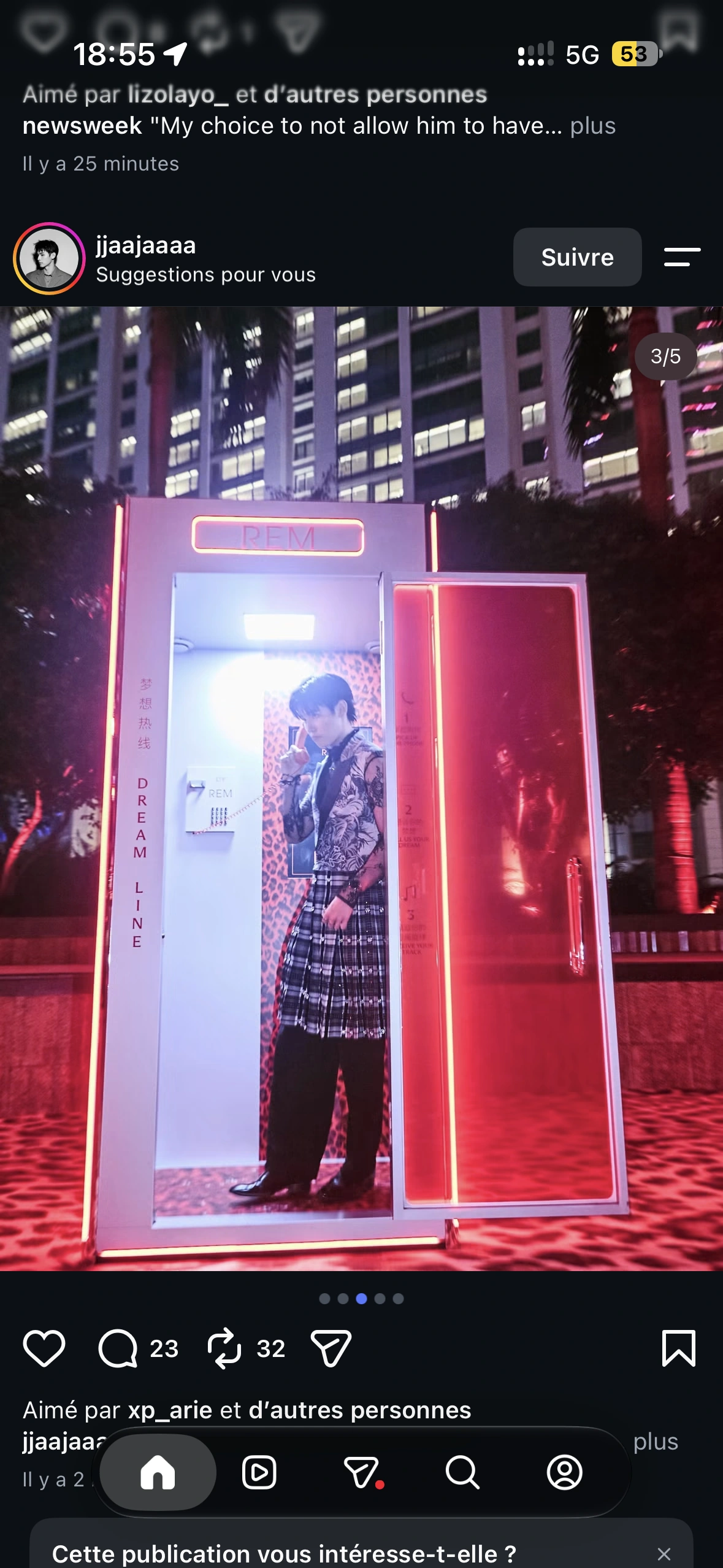 A guest in a lace shirt and patterned vest making a call inside the red Dream Line booth