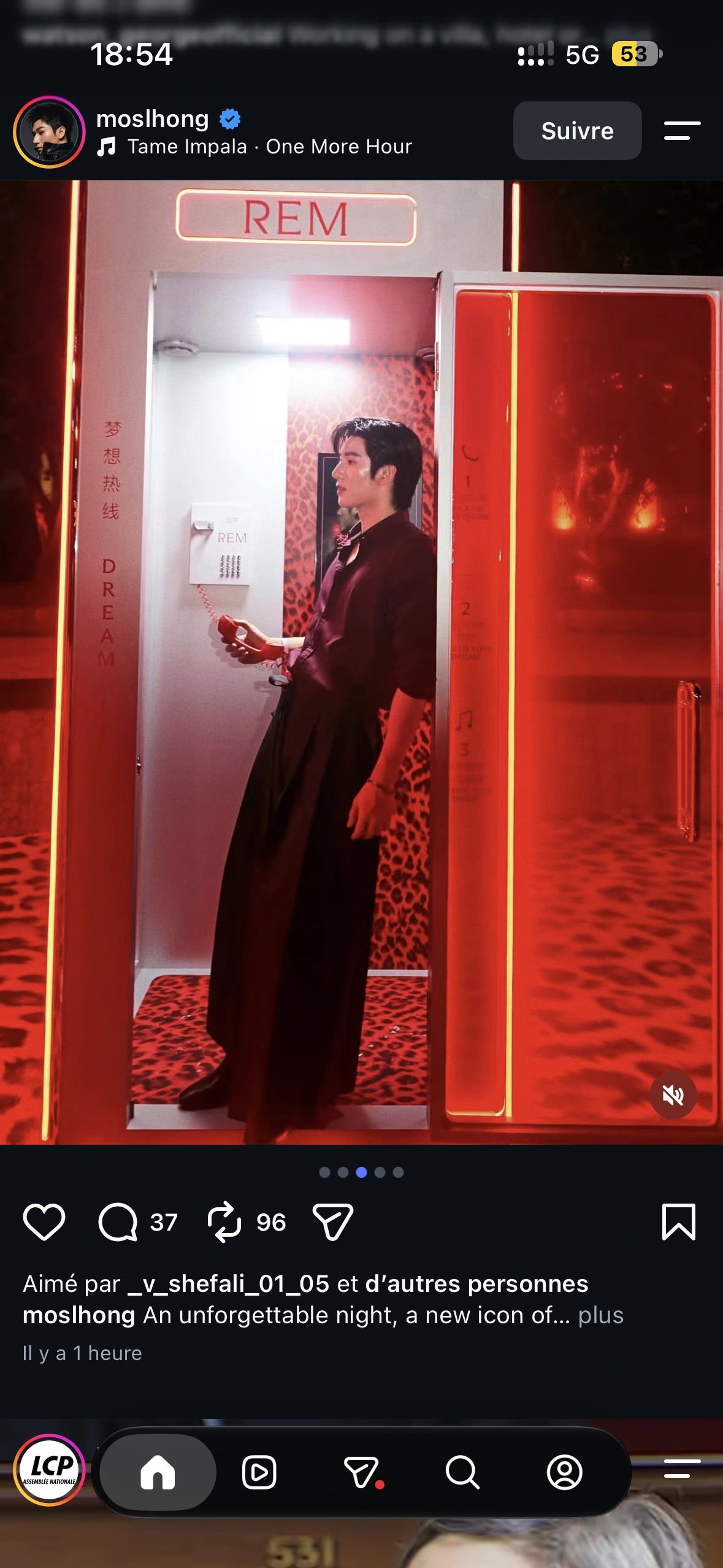 A guest in burgundy holding the red Dream Line receiver in the illuminated booth