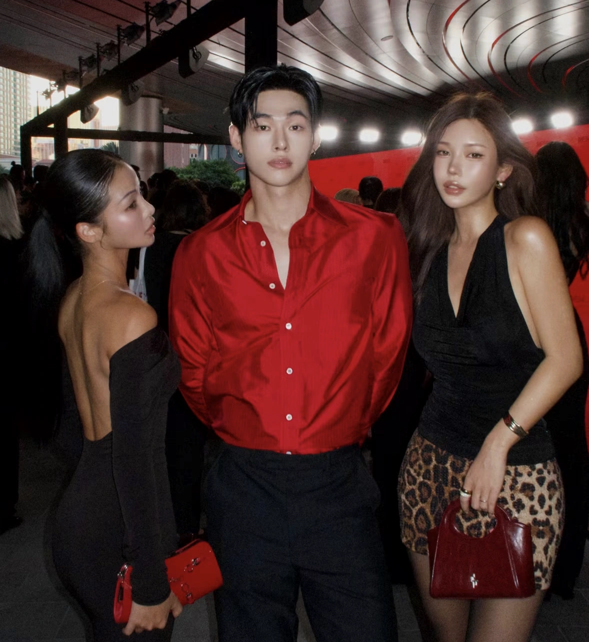 Three guests in black and red at the REM opening-night party