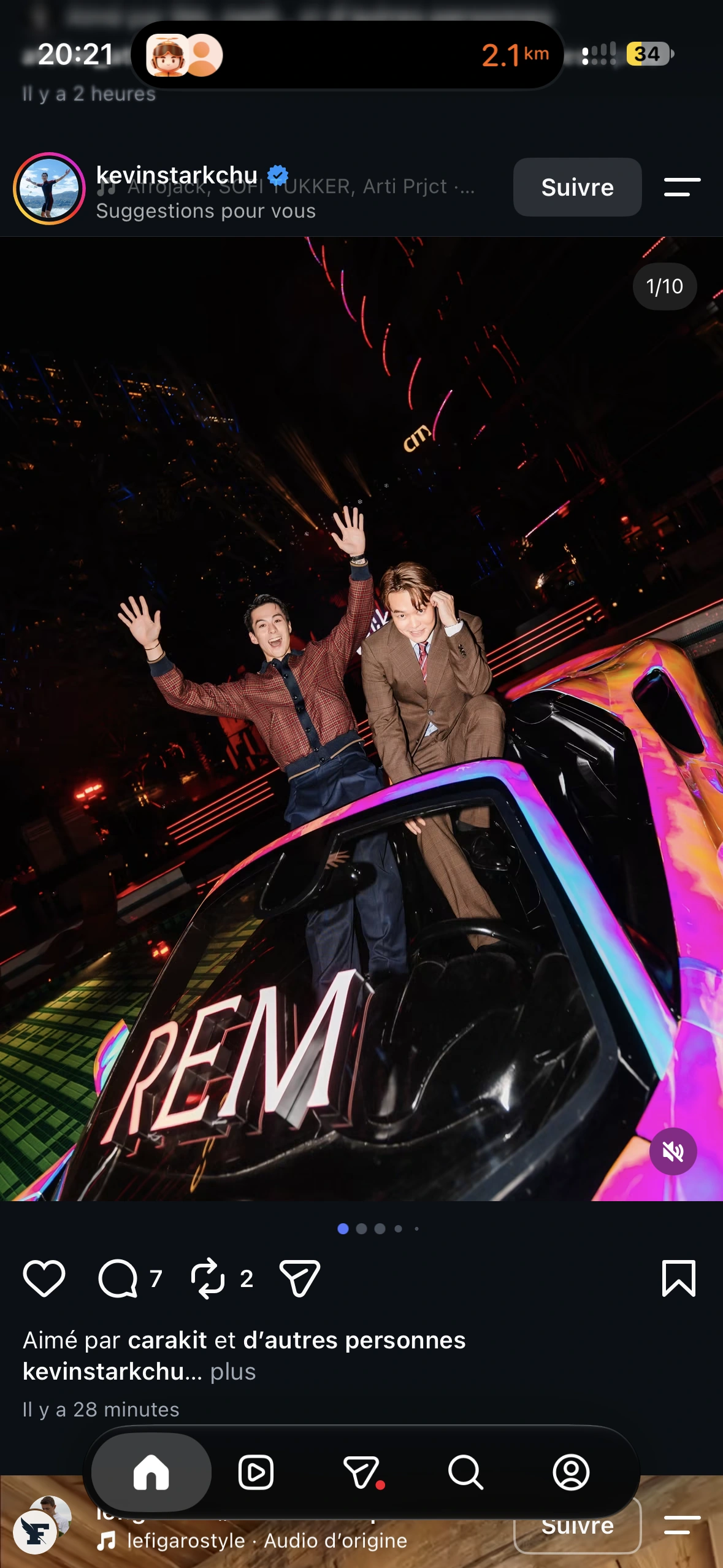 Two guests laughing and waving from the iridescent dream car