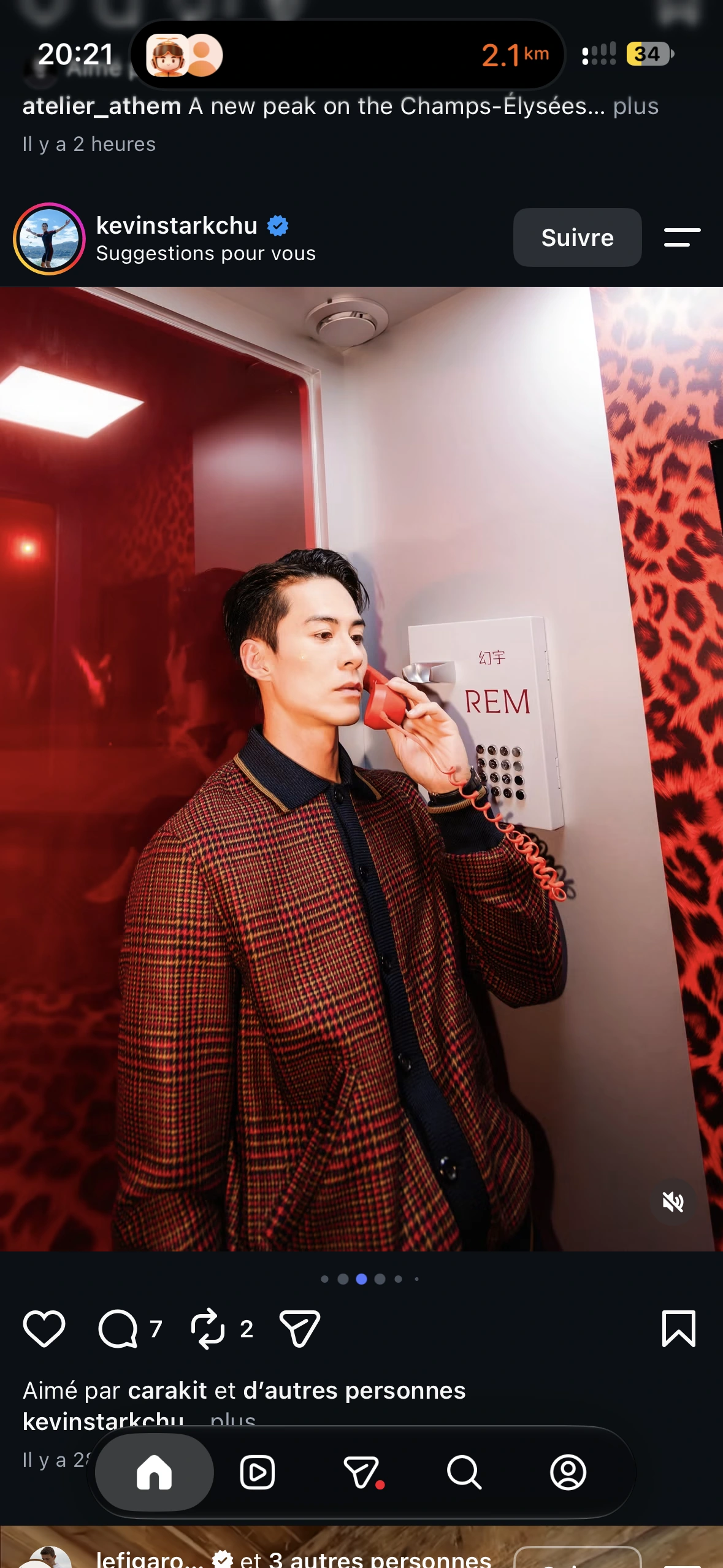 A guest in a checked jacket using the red receiver inside the Dream Line phone booth