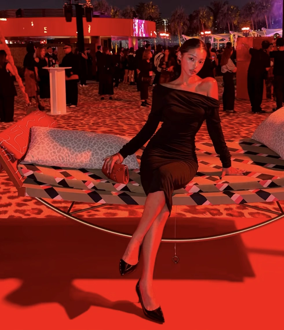 A guest in a black evening dress on the patterned swing at the party