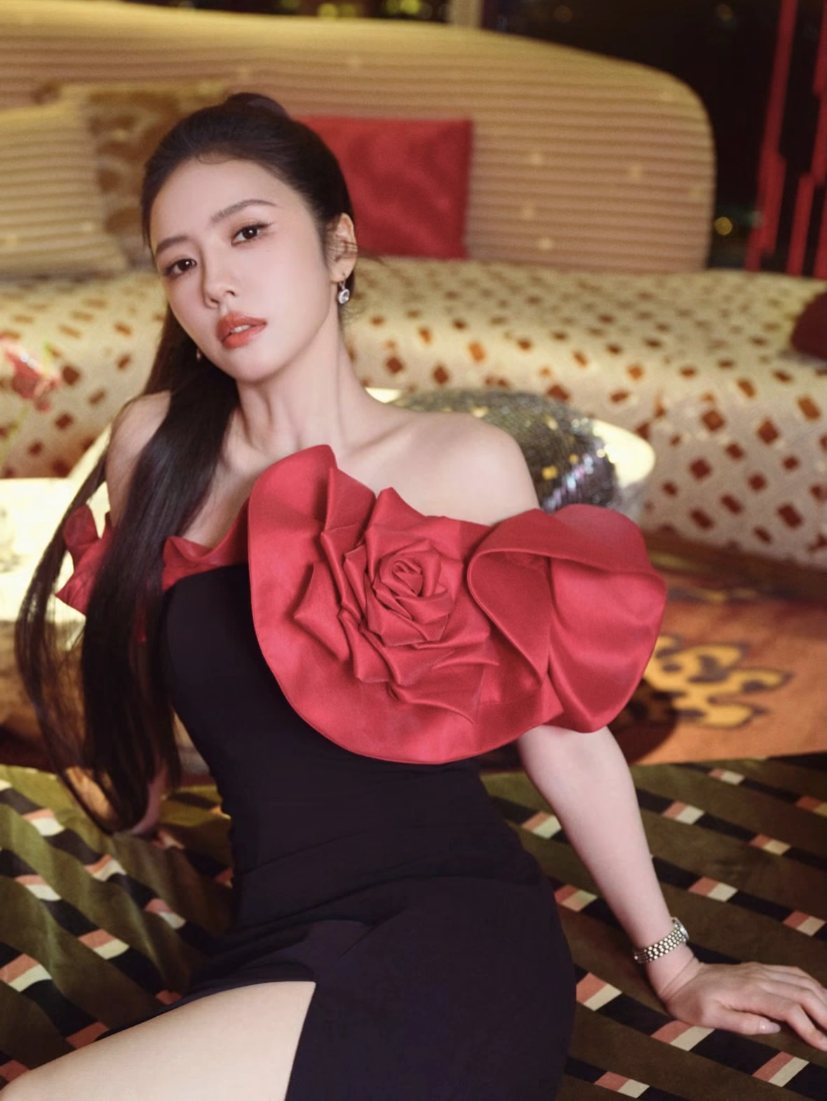 Portrait in a black dress with a red rose detail in a REM hotel interior