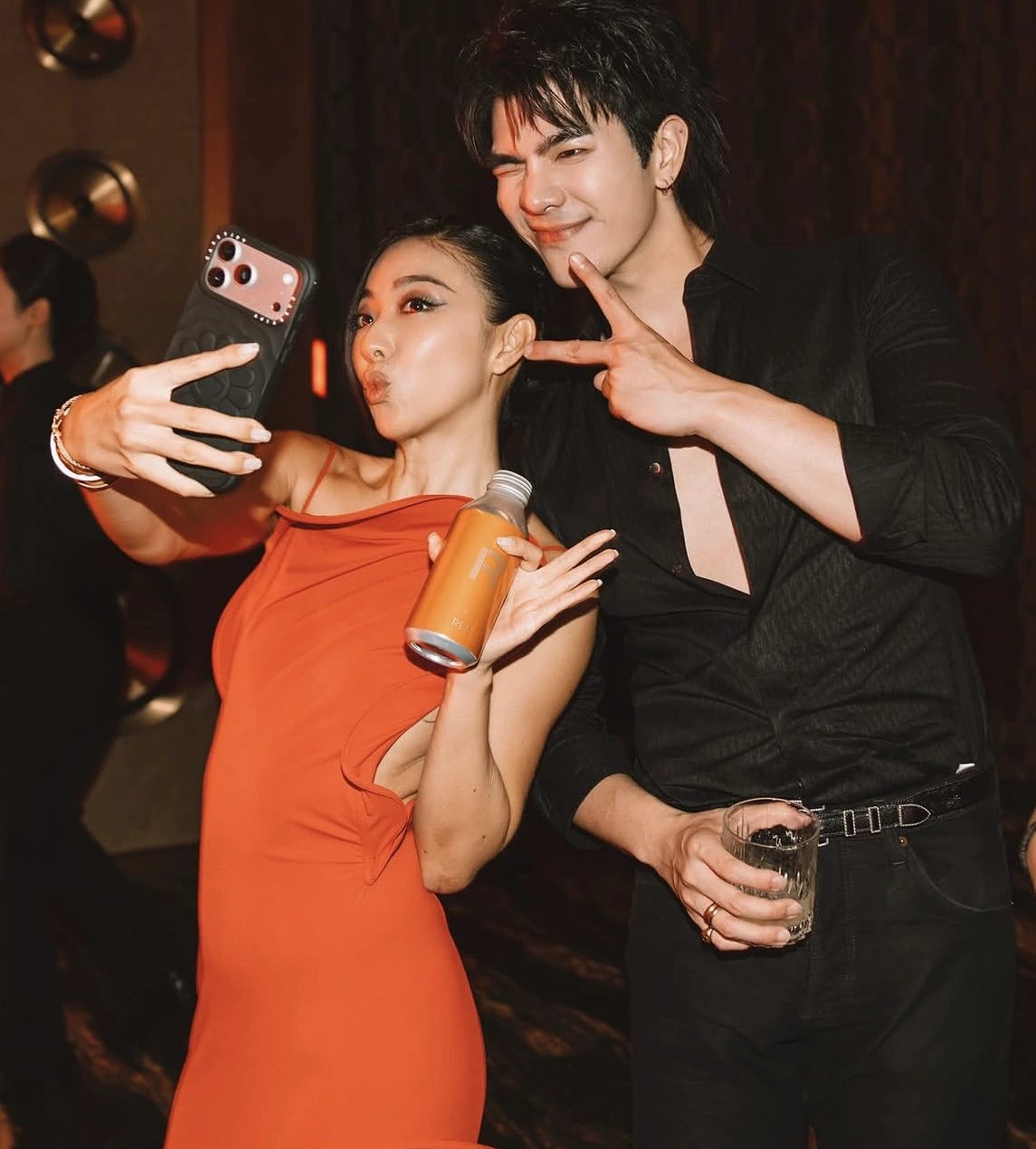 Two guests take a photo together in a warm mirrored setting