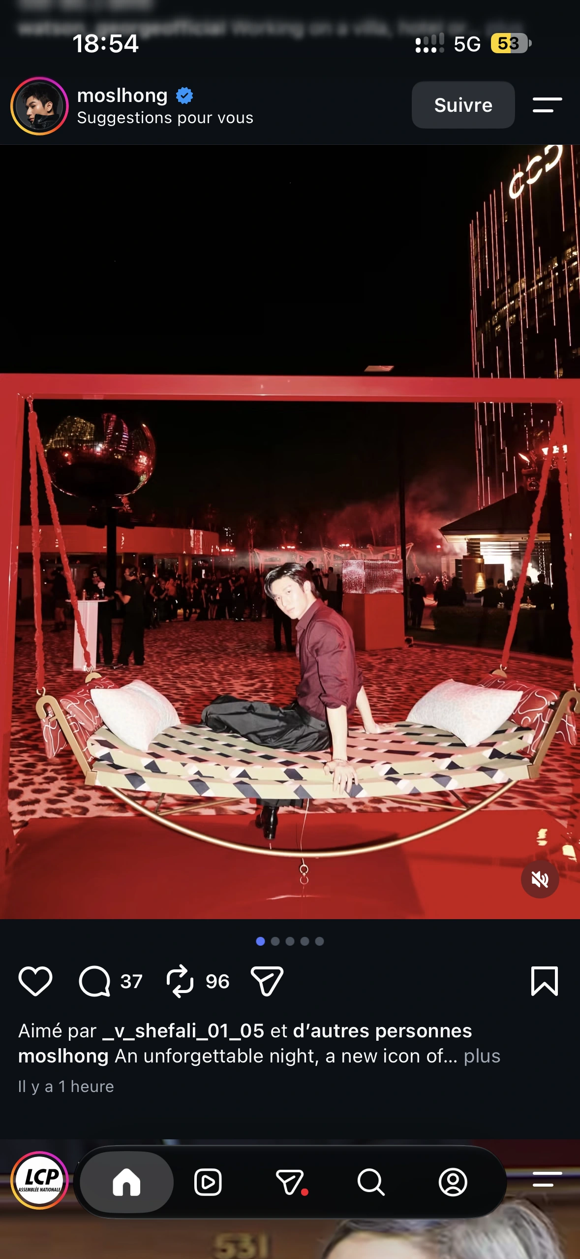 A guest on the suspended patterned swing with the opening-night crowd and disco ball behind him