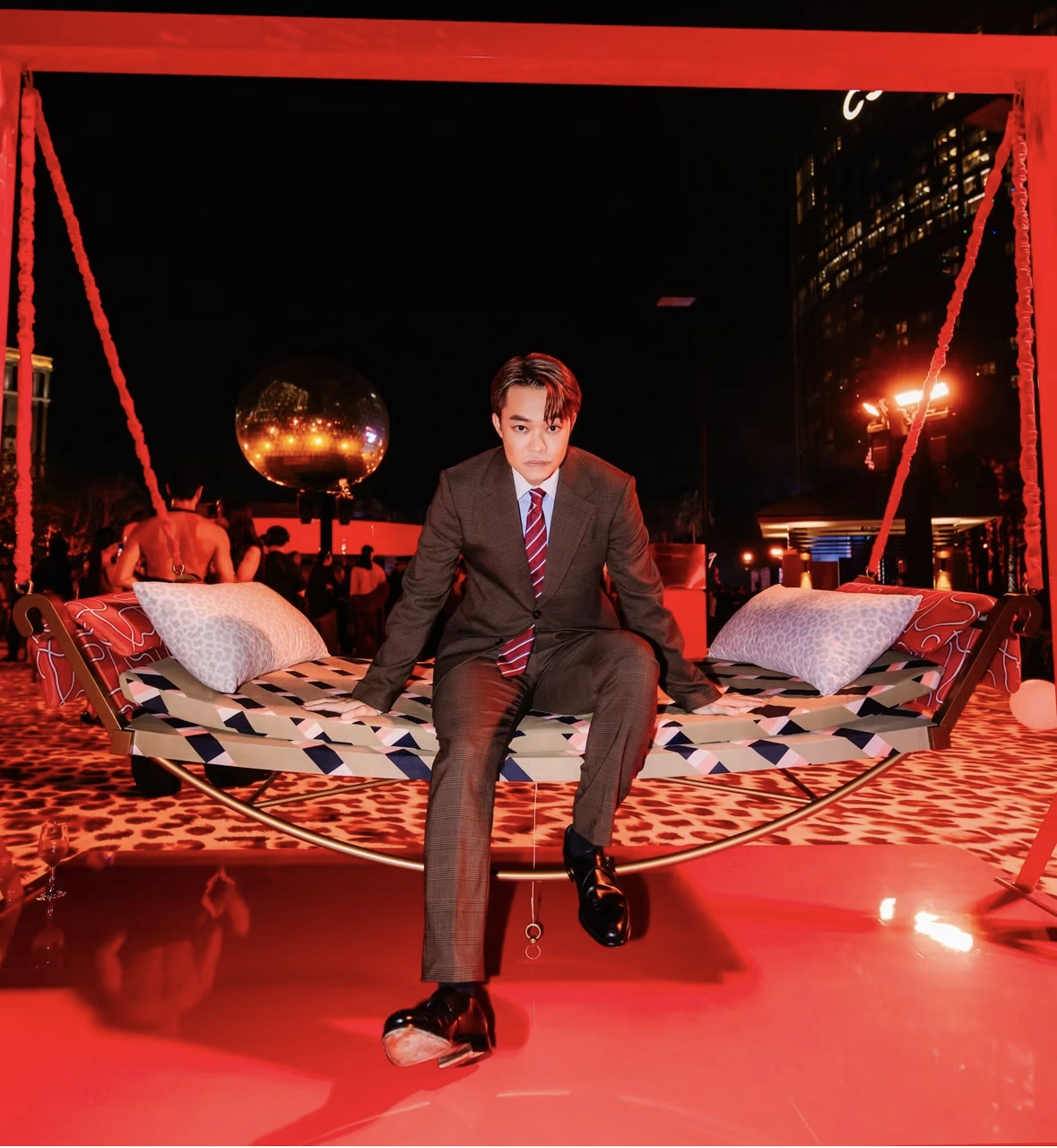 A guest in a suit on the suspended swing at the REM opening night